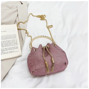Detail of purple rhinestone bucket bag featuring gold metal handle and drawstring tassel