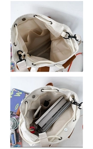 Detail view showing large capacity and multi-pocket interior of the white canvas bucket bag