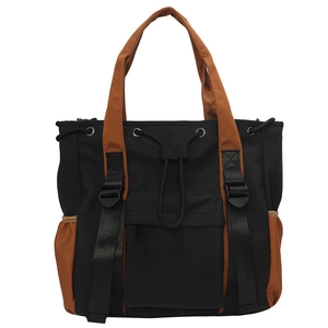 Detail of color-block nylon tote bag showing drawstring closure and vertical straps