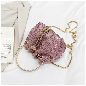 Detail of pink rhinestone bucket bag with silver metal ring handle and gold chain strap