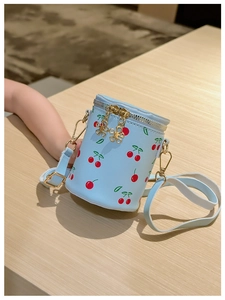 Vue détaillée du sac seau bleu clair à motif cerise avec fermeture éclair dorée