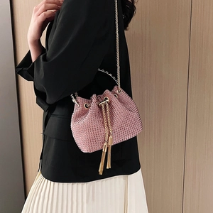 Pink rhinestone bucket bag with gold chain strap and elegant tassel drawstring detail