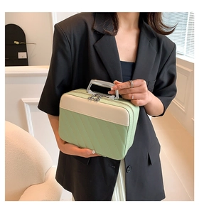Close-up of green quilted rectangular handbag featuring a stylish silver metal handle detail