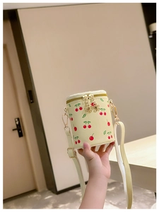 Détail du sac seau à cerises pour filles avec zip fleur dorée et texture en cuir jaune