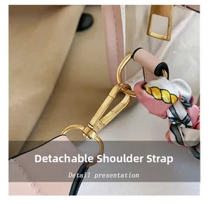 Nahaufnahme der rosa Ledertasche mit goldener Hardware und dekorativem bedrucktem Seidenschal