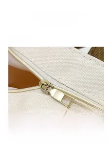 Detailed macro view of gold metal zipper and sturdy canvas texture on tote bag