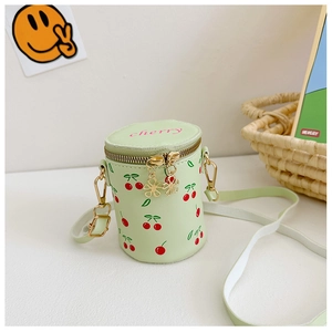 Détail du mini sac seau vert avec imprimés cerises et fermetures éclair à fleurs dorées