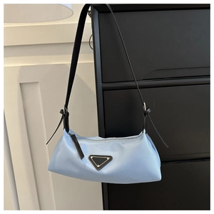 Detailed close-up of light blue crescent shoulder bag with black triangle brand logo