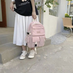 Detailed close-up of pink nylon backpack with functional multi-pockets and woven straps