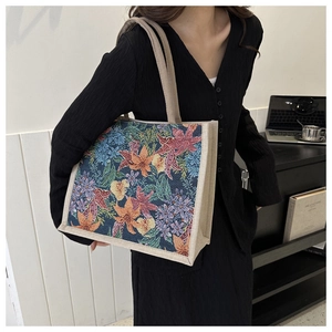Detailed view of vintage floral tote bag worn over the shoulder in a home office setting