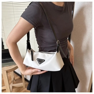 Detail of white nylon baguette shoulder bag with black leather trim and metal triangle logo
