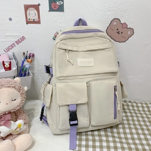 Minimalist beige and purple student backpack with multi-pocket design on a desk
