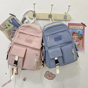 Detail view of pink and blue campus backpacks featuring multi-pocket design and nylon texture