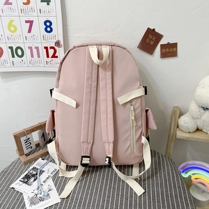 Pink waterproof nylon backpack with adjustable white straps and anti-theft back pocket