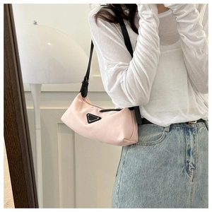 Detail showing pink nylon hobo bag with iconic metal logo and slim black shoulder strap