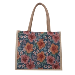 Navy blue canvas tote bag with hibiscus floral pattern and brown braided handles