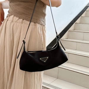 Minimalist black nylon shoulder bag with triangle metal logo and slim leather strap