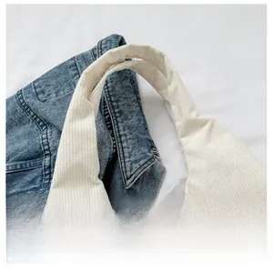 Détail de la poignée du sac cabas en velours côtelé crème avec texture rayée douce