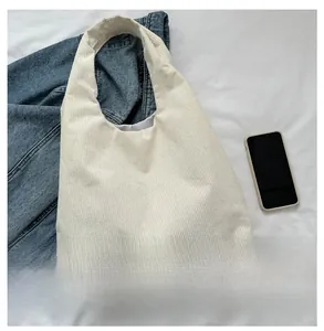 Détail du sac cabas en velours côtelé blanc montrant les rayures et l'étiquette noire