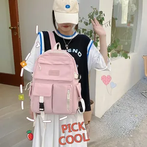 Close-up of pink nylon backpack featuring multi-pocket design and adjustable side buckles