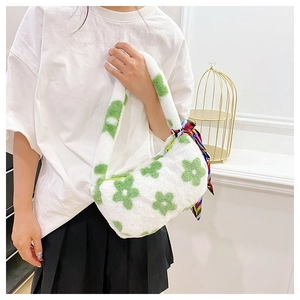 Detail of white plush floral handbag with green flower patterns and colorful silk scarf