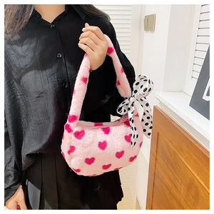 Close-up of pink plush handbag featuring heart patterns and polka dot silk ribbon detail