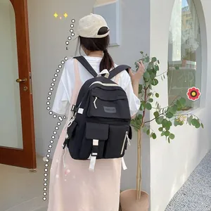 Close-up of black casual backpack with white adjustable straps and multiple zip pockets