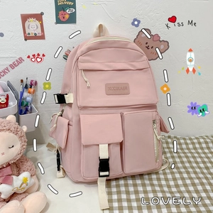 Detail of light pink nylon backpack with multiple functional pockets and buckle straps