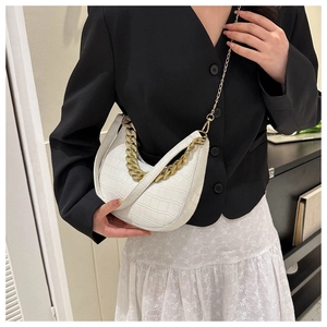 Detalle de bolso media luna blanco efecto cocodrilo con cadena dorada y correa en modelo
