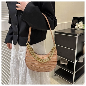 Detalle del bolso hobo rosa con grabado de cocodrilo y cadena dorada en modelo