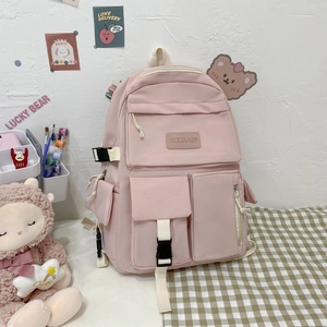 Detail view of pink waterproof nylon backpack showing brand label and multi-pocket structure