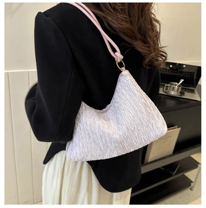Detail of white pleated hobo bag with pink rope straps and elegant gold metal hardware