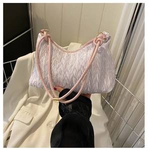 Detail of pleated shoulder bag with pink round handle and gold ring attachment