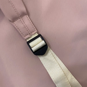 Detail of pink backpack shoulder strap with durable weaving and plastic adjuster