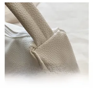 Detailansicht der weißen Kunstleder-Nähte und Reißverschlüsse dieser Handtasche