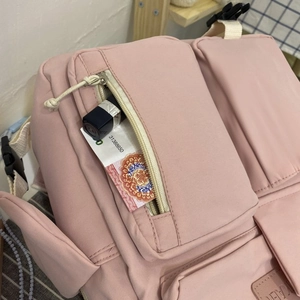 Detail view of pink student backpack showing multiple pockets for storage and organization