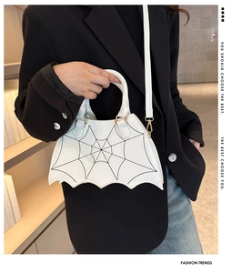 Dettaglio della borsa bianca a pipistrello con cuciture a ragnatela nera e finiture oro