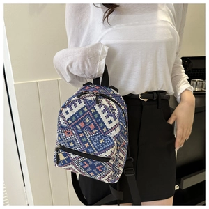 Vue détaillée du motif jacquard ethnique sur un mini sac à dos bleu au tissage précis