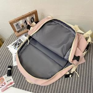 Top view of pink nylon backpack interior showing spacious double main compartments with grey lining