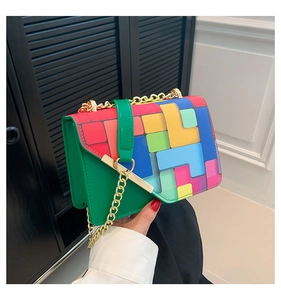 Dettaglio di motivi geometrici colorati e catena dorata sulla borsa a tracolla chic