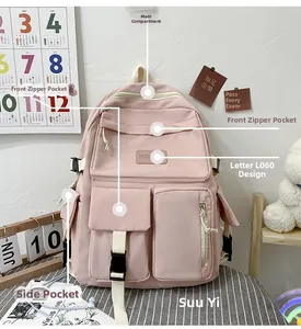 Detail view of pink nylon school backpack with multi-pocket layout and front buckle design