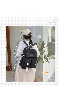 Detail of black nylon backpack featuring cream zippers and multiple storage pockets
