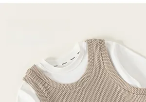 Detail der beigen Strickweste über einem weißen Baumwollshirt mit Markenlogo