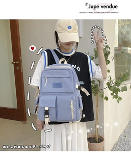 Detail view of lavender blue canvas backpack showing side pockets and webbing straps
