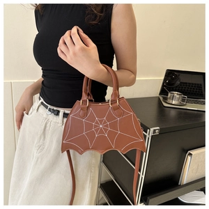 Detailansicht der braunen Fledermaus-Handtasche mit Spinnennetz-Stitching im Lifestyle-Look