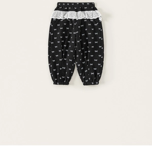 Detailed view of kids trousers featuring lace trim waistband and white bow prints