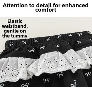 Detailed macro view of elastic waistband with white lace trim and bow print on girls pants