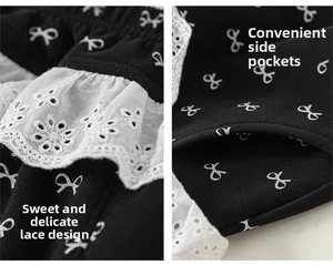Detail view of girls' black cotton trousers featuring bow prints and lace-edged side pockets