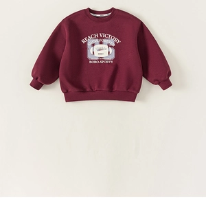 Detail of burgundy boy sweater with rib-knit neckline and reach victory letter print
