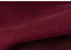 Detailed macro view of soft burgundy knitted fabric texture with fine weave patterns